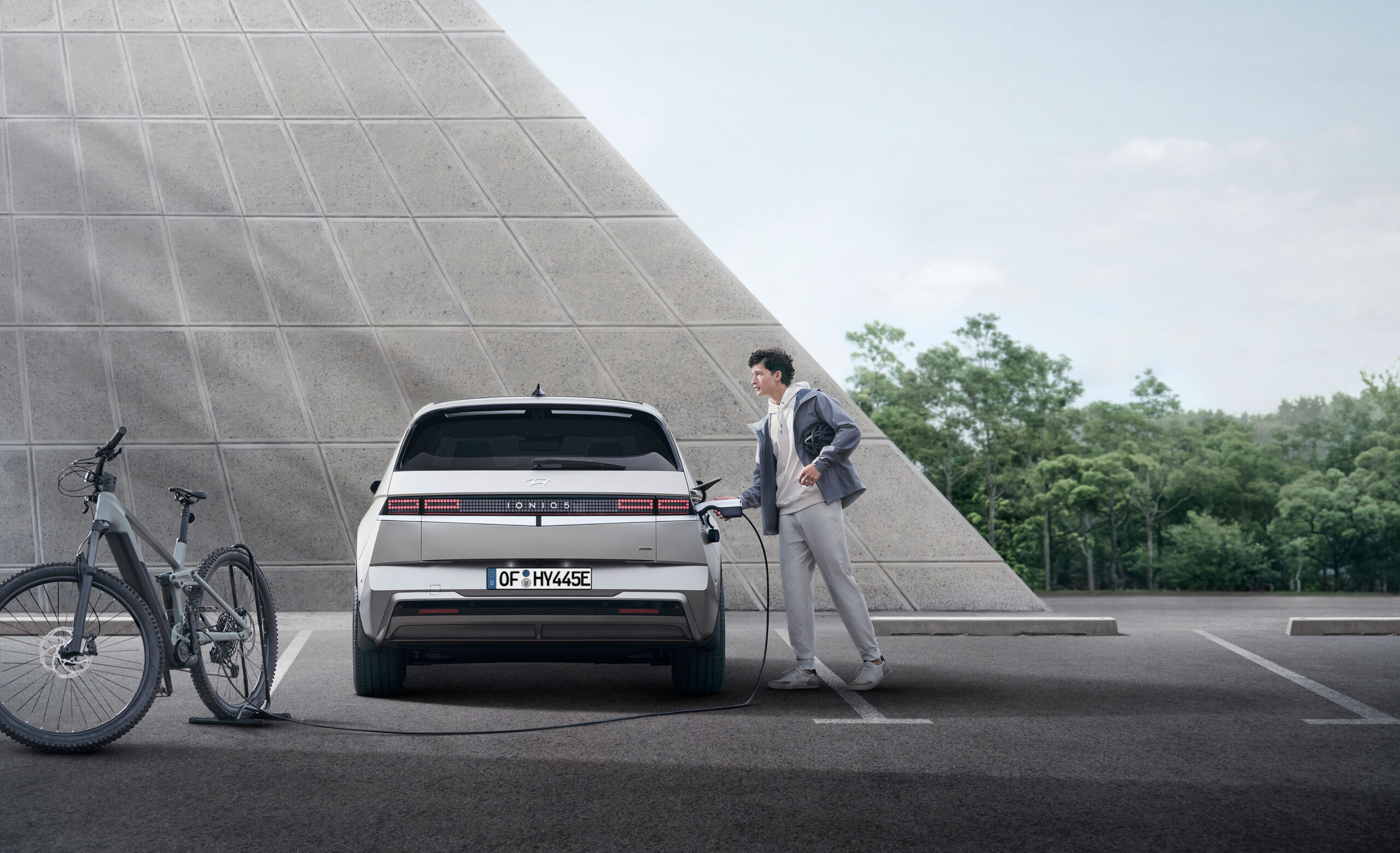 A man charging Hyundai IONIQ 5 N Line in the public parking.